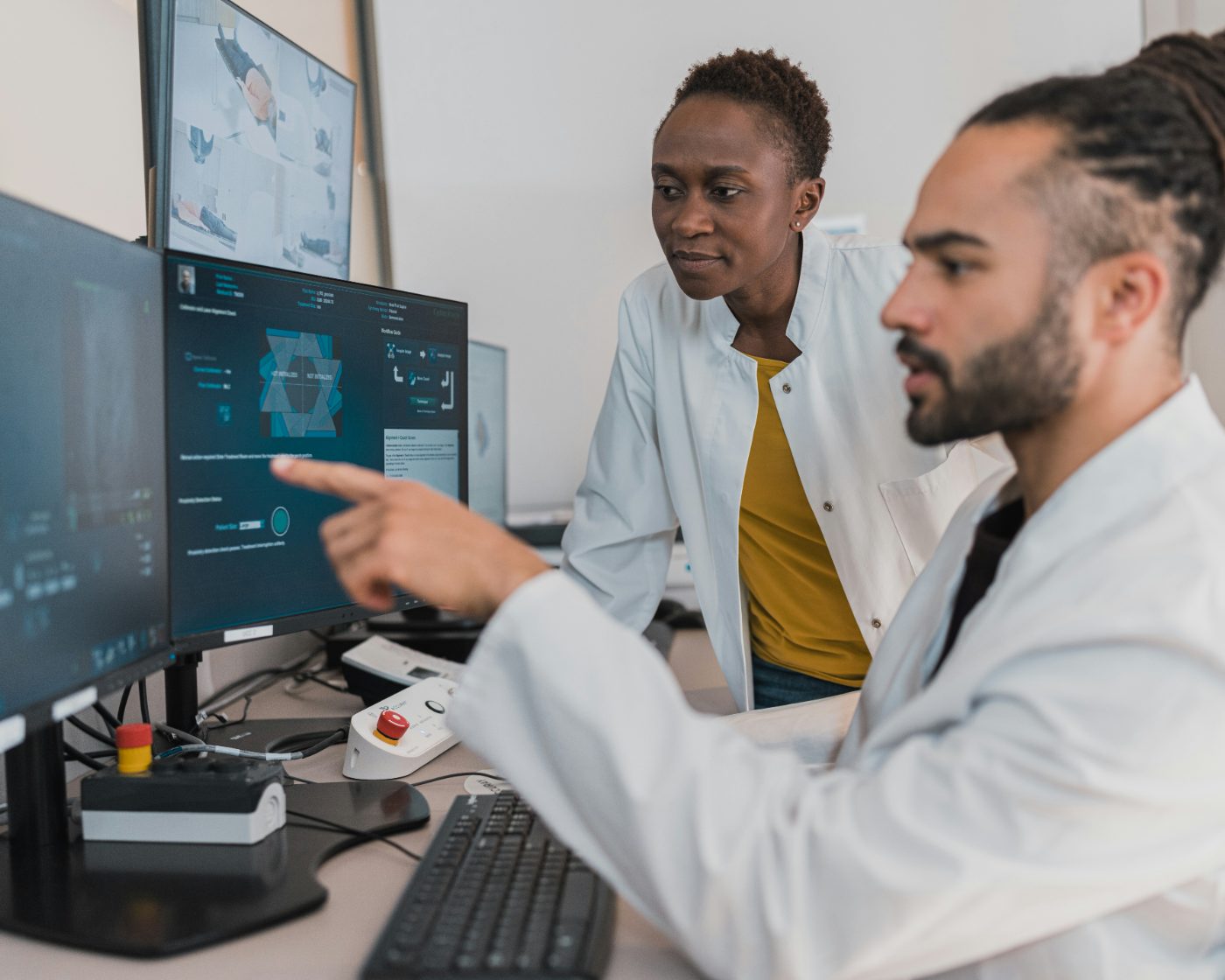 Two clinicians reviewing a treatment planning console in a radiation oncology suite